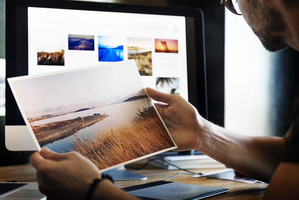 Creative design studio workspace with laptop, camera and sketch materials