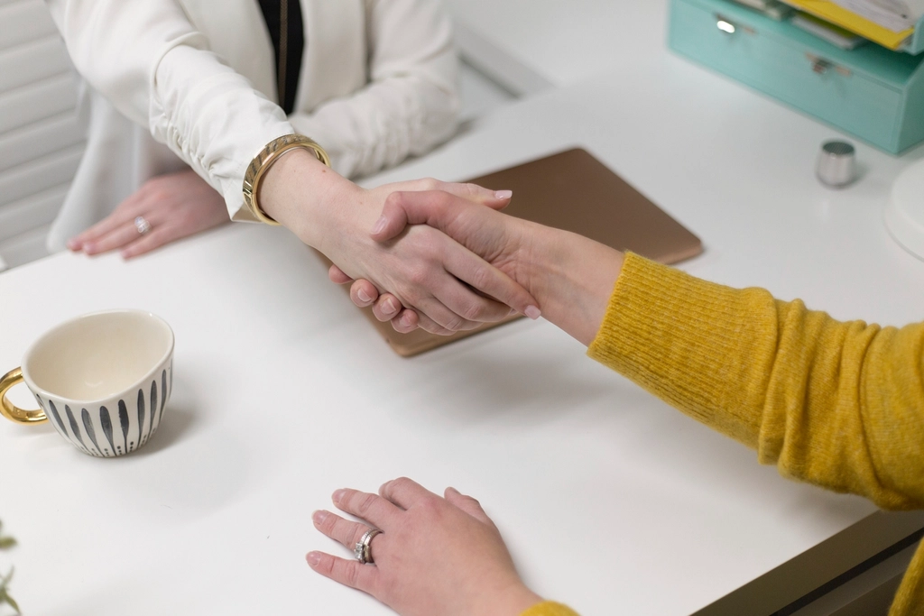 Handshake across a project meeting table